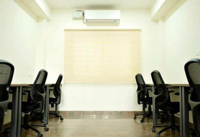 Professional office room with multiple workstations and modern mesh back chairs.
