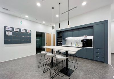 Breakout space with a high communal table and a wall-mounted mail slot system for tenants.