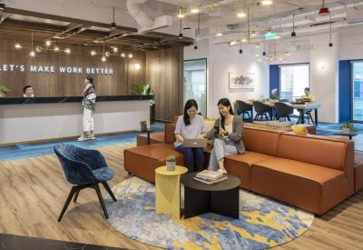 Modern reception area featuring a long white desk and a large tan leather sofa.