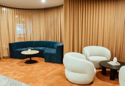 Stylish breakout space with white tub chairs and a dark coffee table.