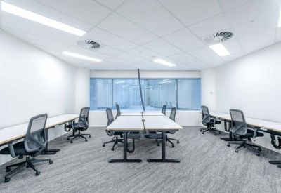 Co-working space with rows of height-adjustable desks and ergonomic seating.