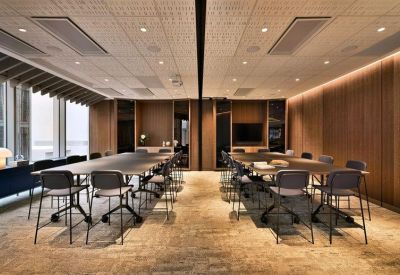 Bright conference room featuring two long modular tables and ergonomic task chairs.