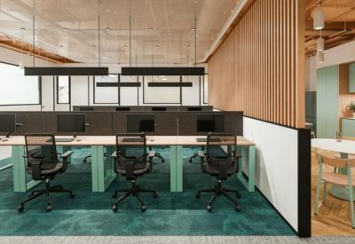 Open-plan workspace with teal carpeting, wooden desks, and a slatted timber partition wall.