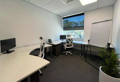 Private office suite with two workstations, ergonomic chairs, and a whiteboard.