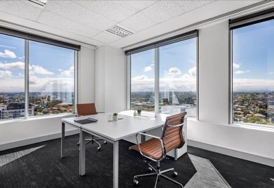 Private office featuring expansive city views through large windows.