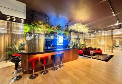 Sleek bar area with red stools, under-counter lighting, and a modern chandelier.