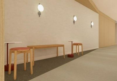 Seating area in a corridor with wooden stools, a bench, and modern wall sconces.