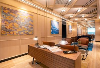 Reception lounge with wood-paneled walls, abstract art, and comfortable leather seating.