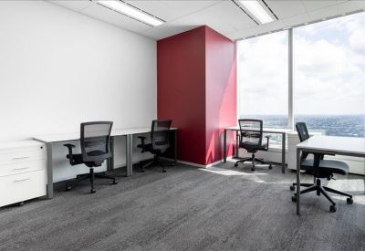 Bright corner office suite with four workstations and expansive window views.