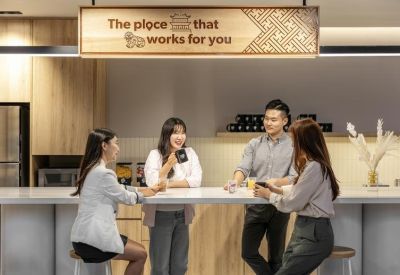 Breakout area with a long white counter and a wooden sign above people talking.