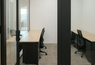 Private glass-enclosed office suite featuring two desks and ergonomic chairs.