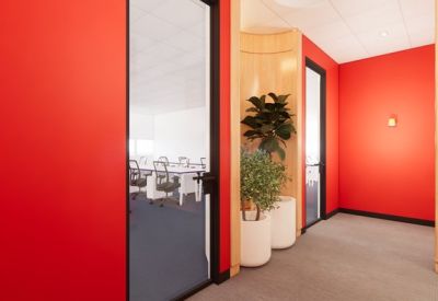 Corner breakout area with bright red walls and indoor plants.