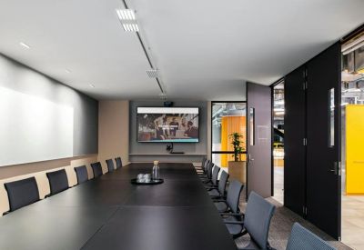 Professional boardroom with a dark wood table and integrated presentation screen.