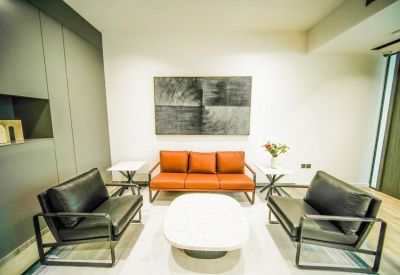 Modern lounge area with leather seating and abstract wall art.
