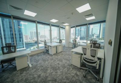Bright corner office with multiple workstations and panoramic city views.