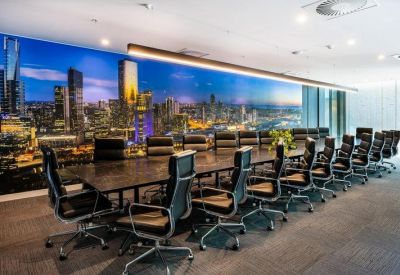 Large boardroom with an expansive city skyline mural and a long dark wood table.