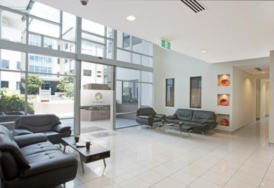 Lobby area with leather couches and glass entrance.