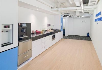 Bright pantry area with white cabinetry, a coffee machine, and light wood flooring.