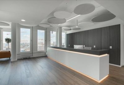 Reception desk with a backlit white counter and decorative circular ceiling panels.