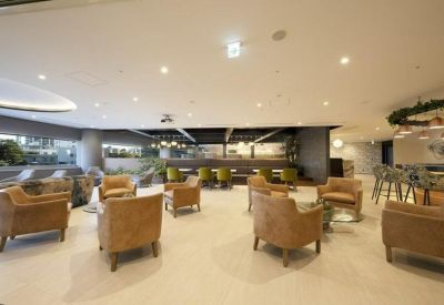 Spacious communal lounge with leather armchairs and modern lighting.