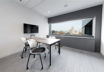Bright private office suite with a city view through a large window.