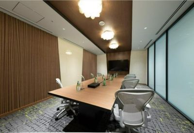 Long boardroom with wood-paneled walls and ergonomic mesh chairs.