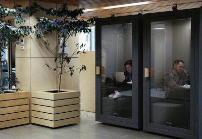 Modern soundproof phone booths for private calls located next to indoor greenery.