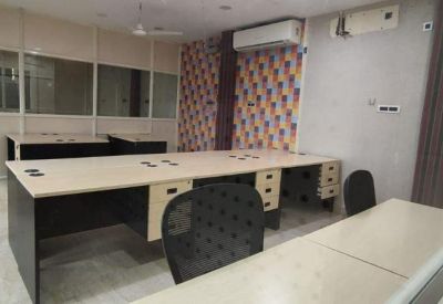 Large open-plan workspace with a multi-person desk and a colorful geometric feature wall.