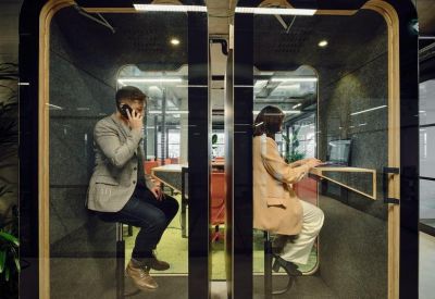Individual soundproof glass phone booths for private calls with integrated seating and desks.