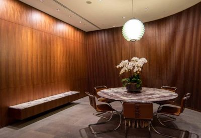 Intimate circular meeting table with leather chairs under a large spherical pendant light.