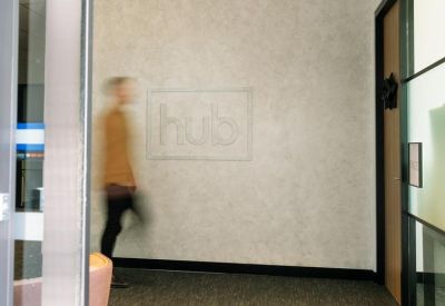 Minimalist hallway featuring a textured grey wall with a subtle engraved logo.
