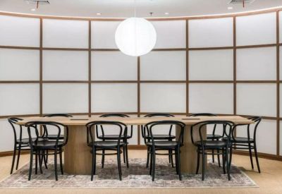 Formal boardroom featuring a long wooden table and mid-century modern chairs.