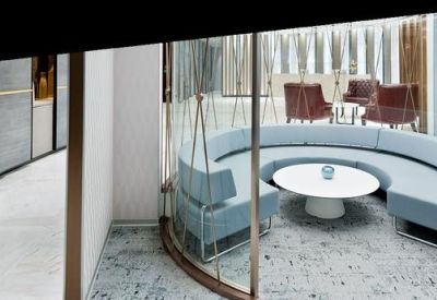 Circular light blue booth seating inside a glass-walled lounge area.