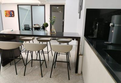 Shared workspace with a long dark wood table and several beige bar stools.