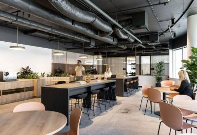 Large breakout area with high-top tables, industrial ceilings, and round dining tables.