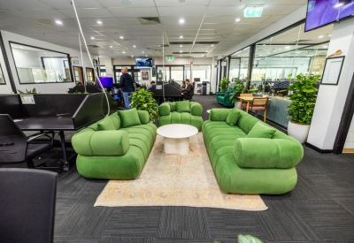 Lounge area with modular green sofas and a white coffee table.
