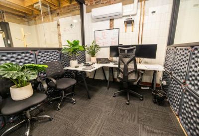 Open plan office space with desks and mesh office chairs.