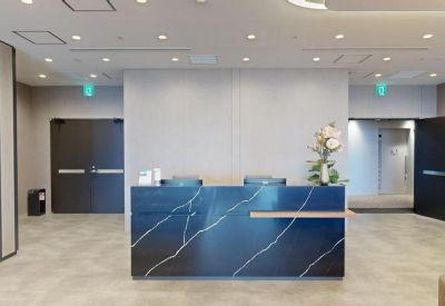 Reception area featuring a dark marble-patterned desk and minimalist white walls.