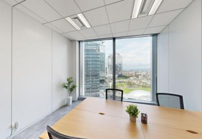 Private four-person meeting room with wooden table and floor-to-ceiling windows.