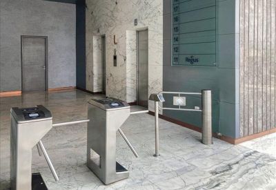 Building lobby entrance featuring electronic security turnstiles and marble-patterned floors.