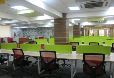 Large open-plan office space with numerous workstations and warm wood-wrapped pillars.