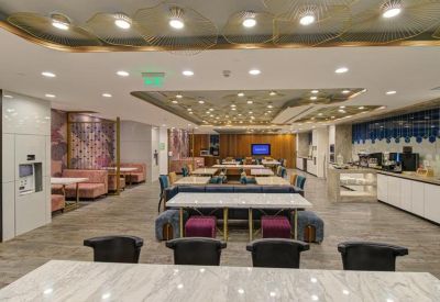 Communal dining and breakout area with a coffee station and mix of booth and table seating.