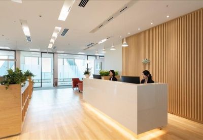 Modern reception area with a sleek white desk and vertical wood slat wall.