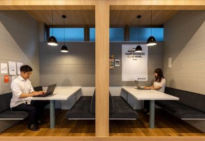 Private wood-paneled work booths with plush seating and warm pendant lighting.