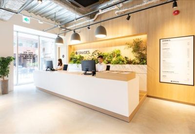 Bright, modern reception desk featuring a lush green plant wall and minimalist design.