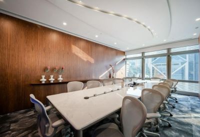 Large boardroom featuring a white table, mesh chairs, and a wood-paneled accent wall.