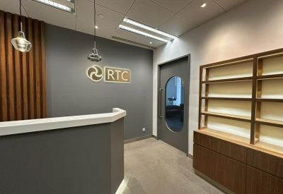 Reception area with branding and a wall-mounted logo.