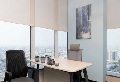 Private office featuring a wooden desk and mesh chair with expansive city views.