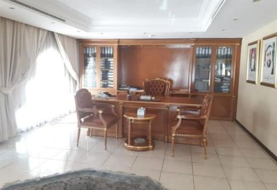 Traditional reception area with wood paneling, artwork, and a credenza.