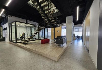 Lobby area featuring an industrial staircase, glass enclosures, and comfortable lounge seating.
